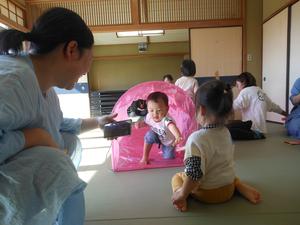 トンネルをくぐる男の子と出口で待つママとお友だちの写真
