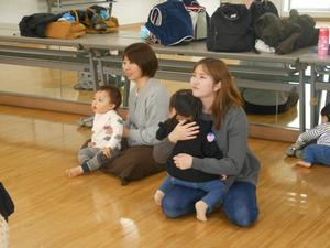 講師の先生による読み聞かせの実演を見ている親子の写真