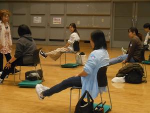椅子に座って足を上げる、簡単な筋トレをしている様子