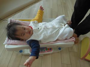 体重を測定している赤ちゃんの写真