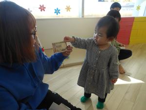ママにお年玉の10000円札（偽ものです）を渡す女の子の写真