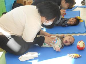 ママにお腹をさすられて喜ぶ赤ちゃんの写真