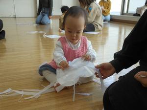 ちぎったお花紙をつけて、雪だるまを作る女の子の写真