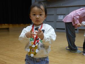 フープ取りで1位になりメダルを勝ち取った男の子の写真