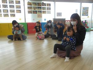 3月3回目の読み聞かせで、親子で手遊びを楽しんでいる様子