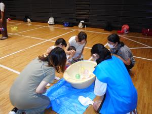 ママと水風船のヨーヨー釣りをしている様子