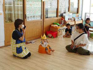 冠をかぶってみんなの前で座っている主役の女の子