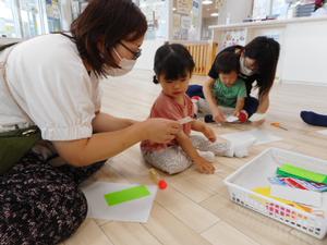 ママとぴょんぴょんガエルを作る女の子の写真
