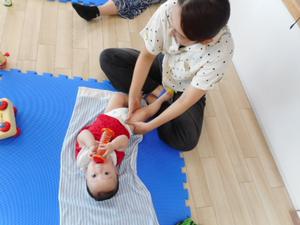 ママにベビーマッサージしてもらっている男の子
