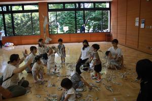 びりびりにちぎった新聞紙を投げて遊ぶ様子