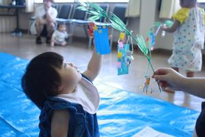 完成した笹飾りを見上げる女の子