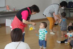 先生から折り紙で作ったひよこをもらう男の子