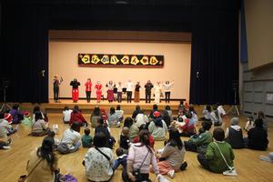 市内3ヶ所の子育て支援センターの職員達がステージに並んで挨拶している様子